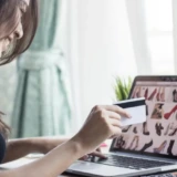 ネットショッピングでクレジットカードを取り出す女性